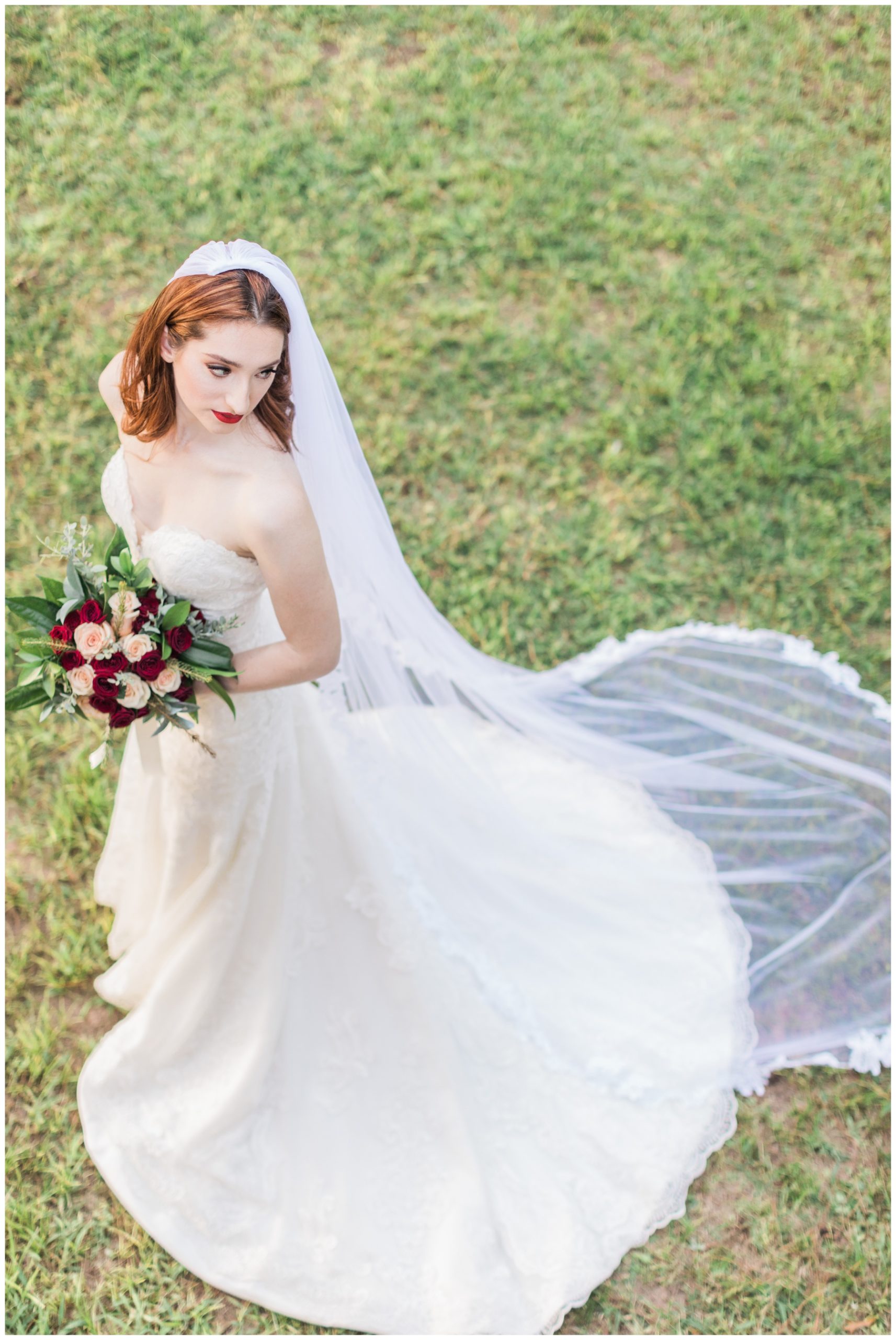 Bride in a lace trumpet gown with red and blush rose bridal bouquet