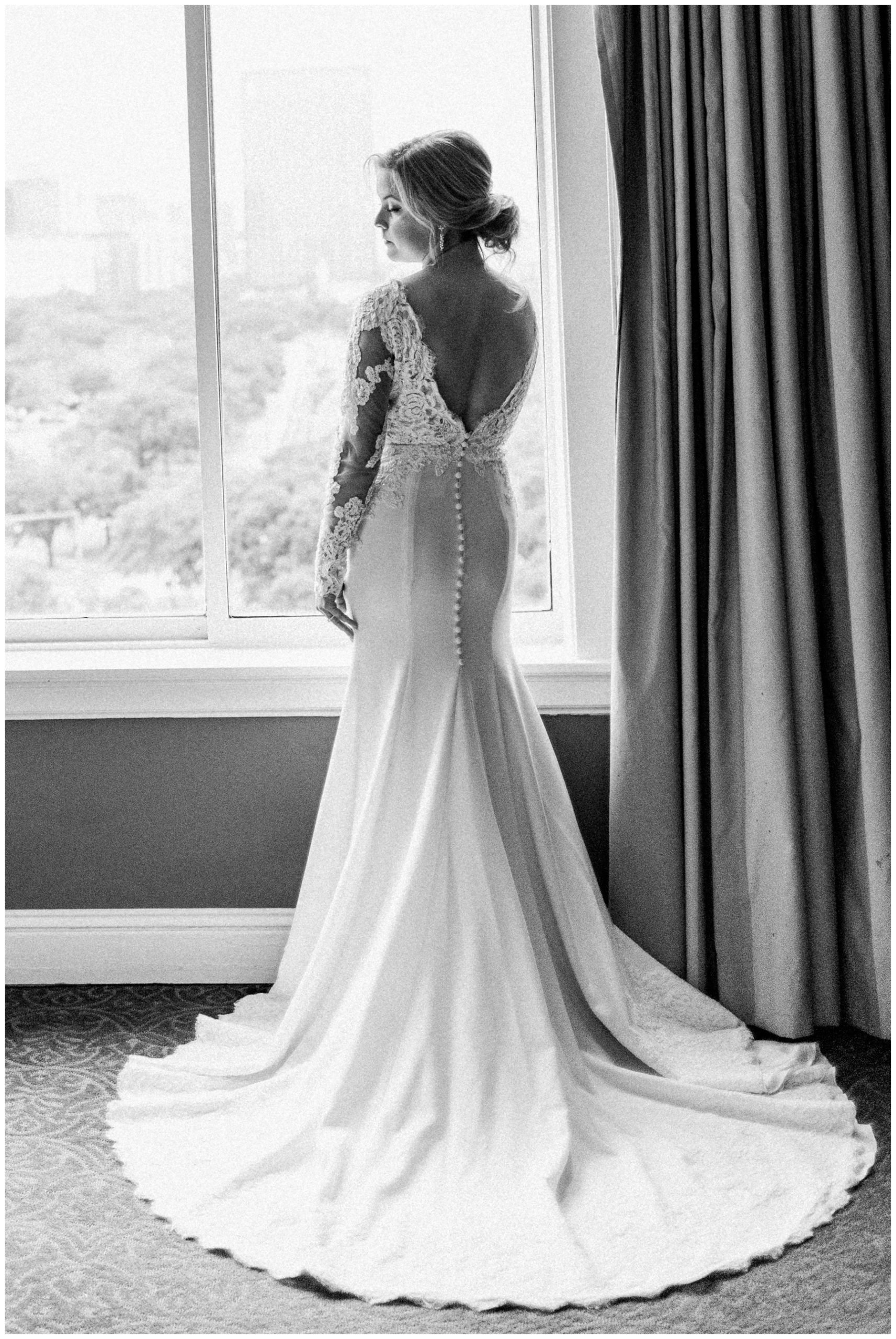 Bride in a lace wedding gown with a deep v neckline and mermaid skirt