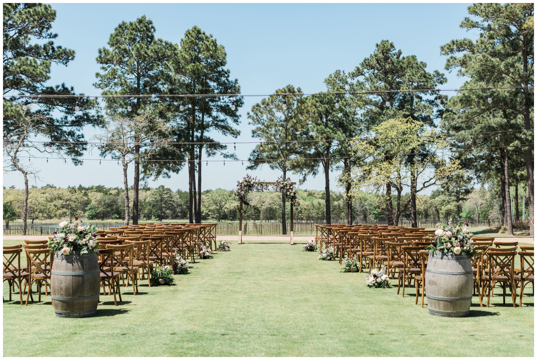 Wooden bistro chairs and a rectangular wooden arch with roses and thistle for a spring outdoor wedding ceremony