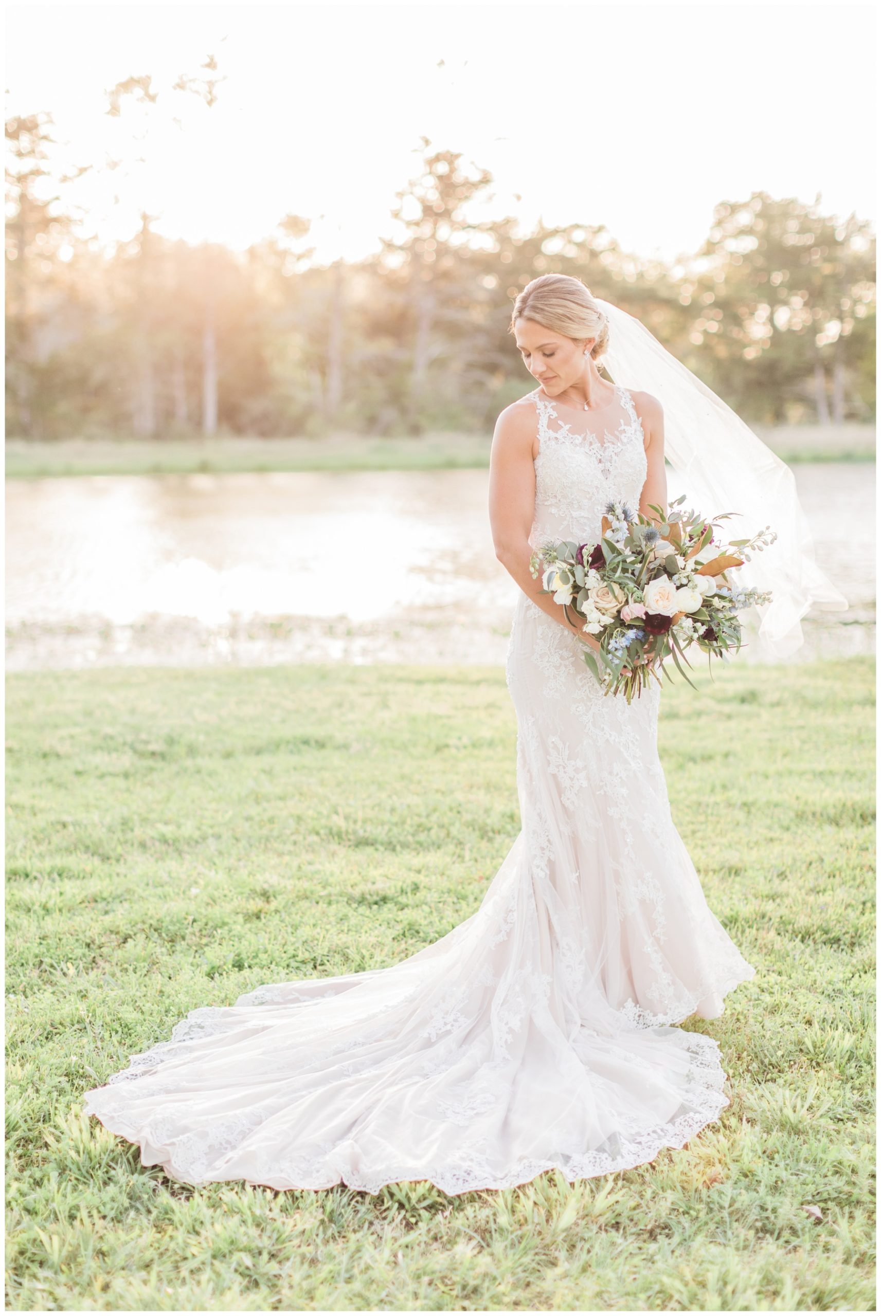 Bride in a lace wedding gown with a sweetheart neckline and chapel train