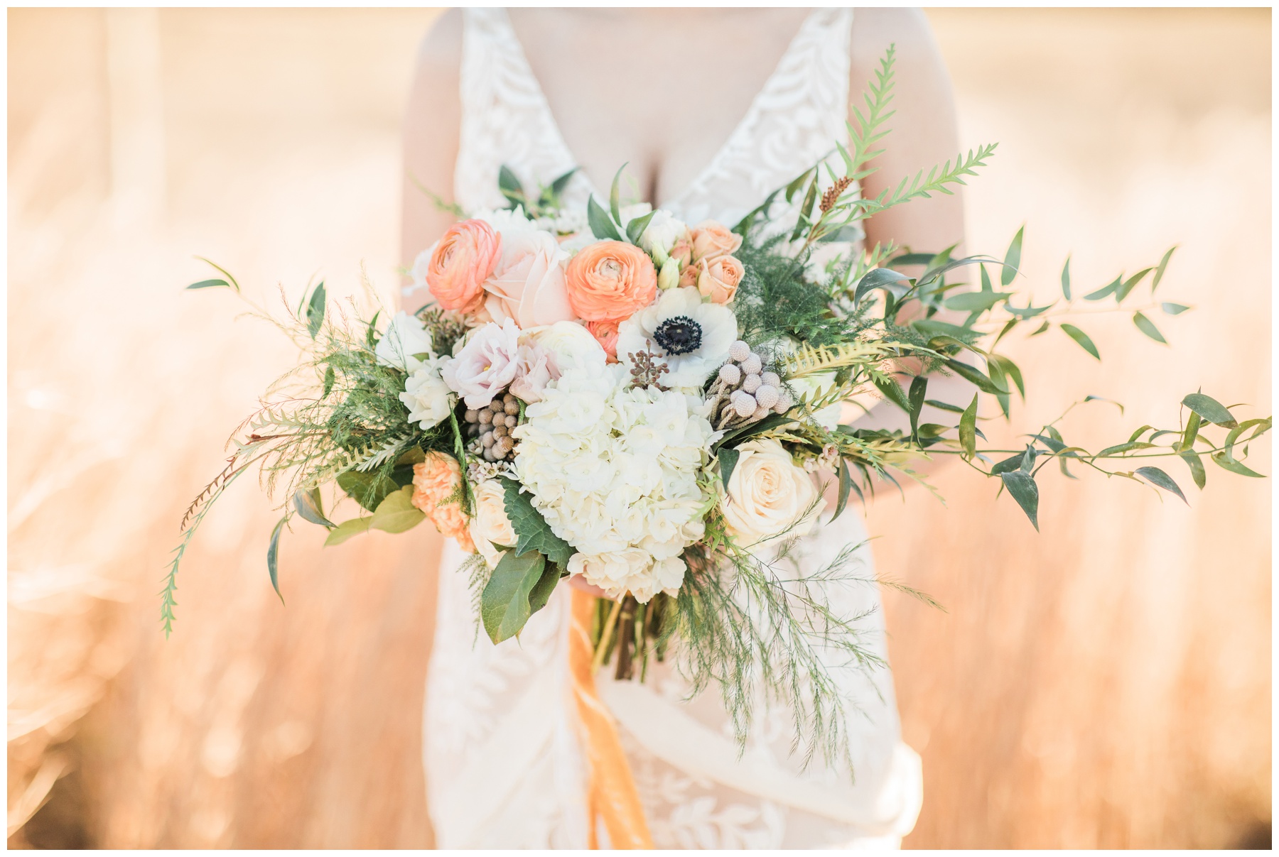 Bridal bouquet filled with cream roses, peach ranunculus, and anemones by Analicia's Flower Shop