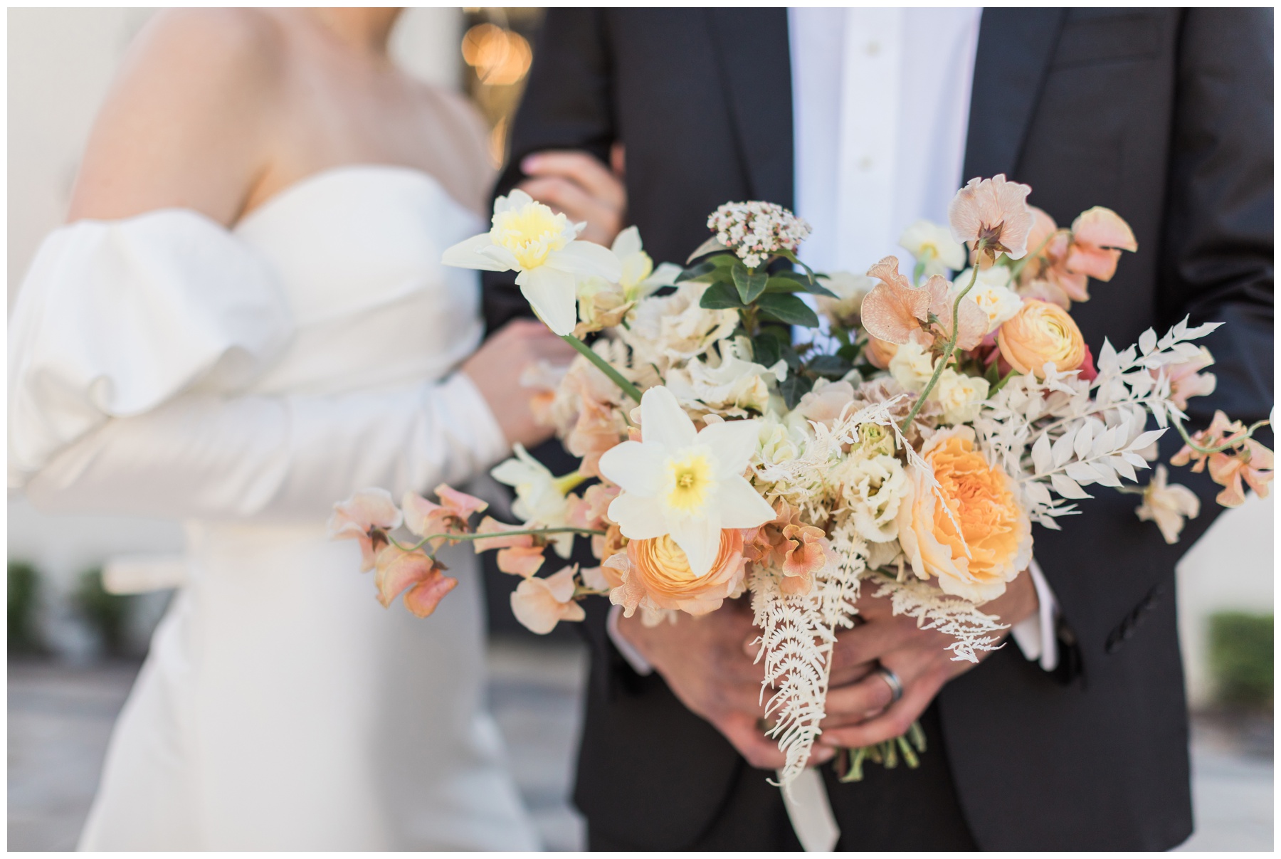 Bridal bouquet filled with pink roses, pink sweet pea, and peach ranunculus by Blush Floral Co.