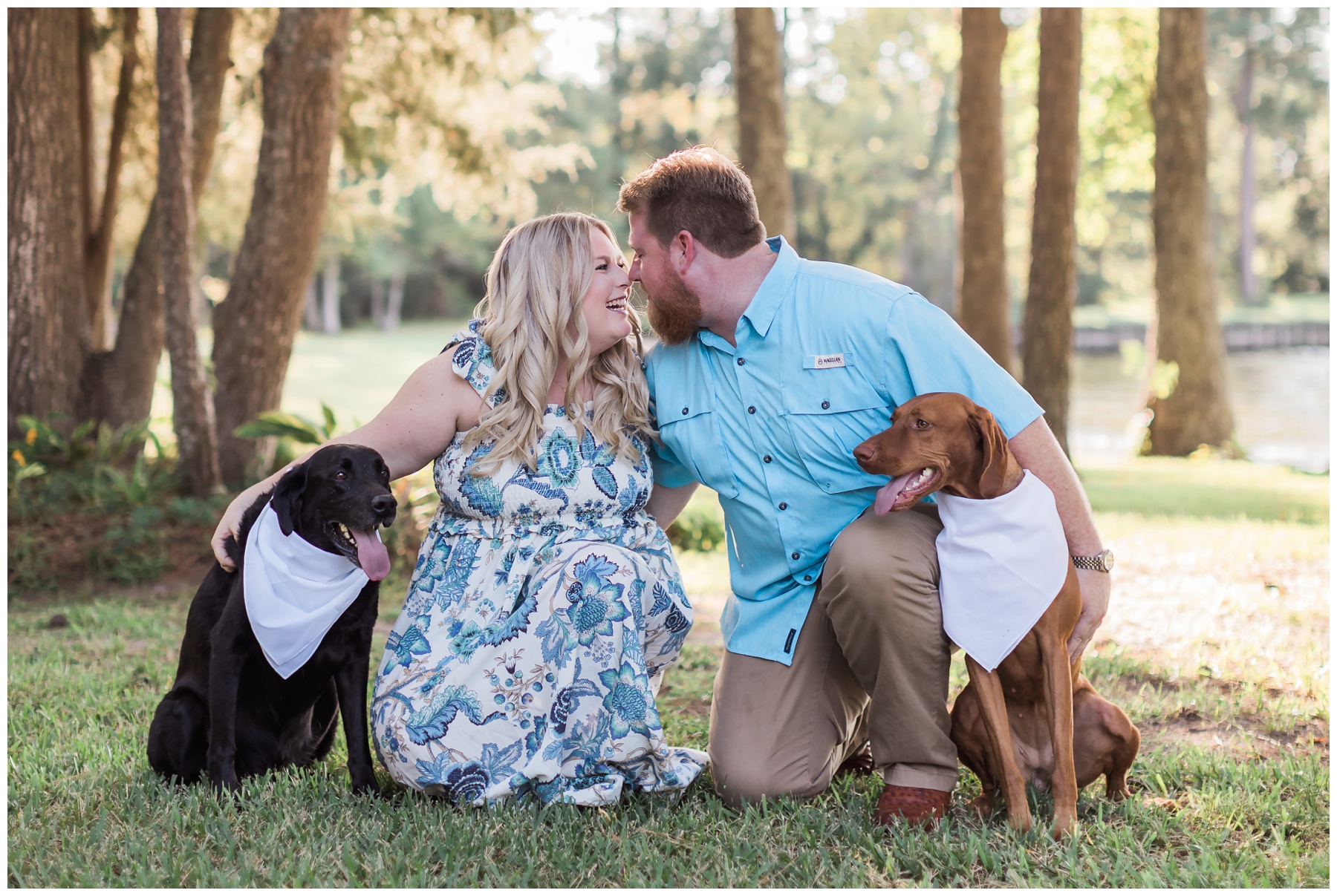 A couple taking engagement photos with their dogs