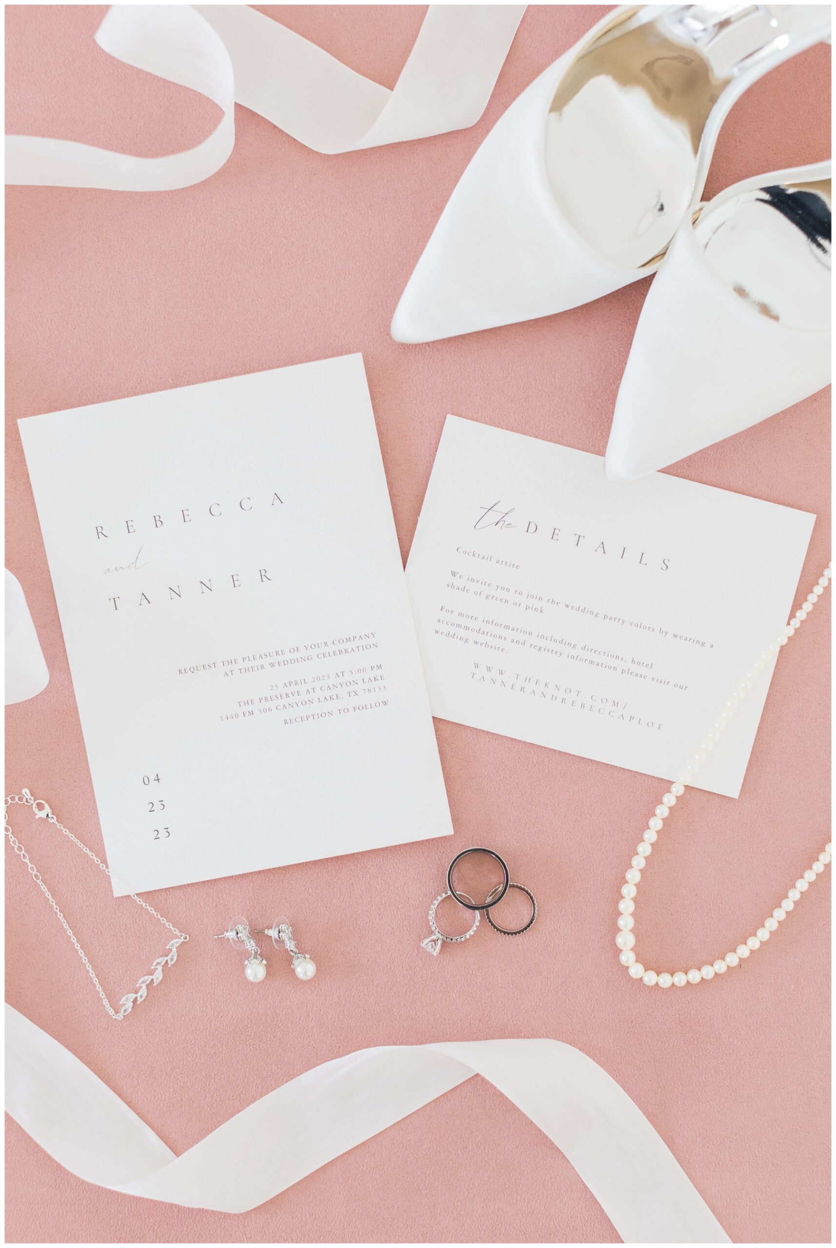 Flatlay of a classic wedding invitation with pearl jewelry and Badgley Mischka wedding shoes