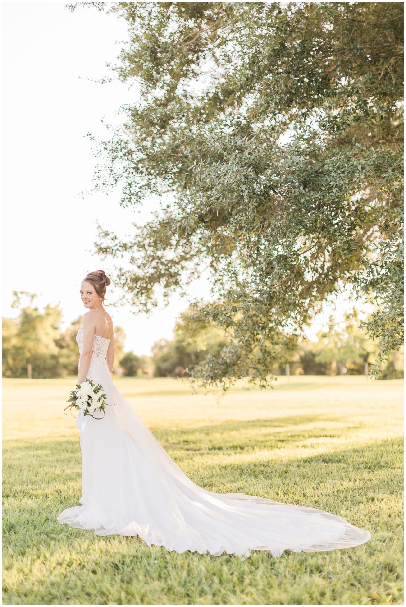 Bride wearing a strapless lace wedding gown with a tulle overskirt for her bridal session at Willowynn Barn