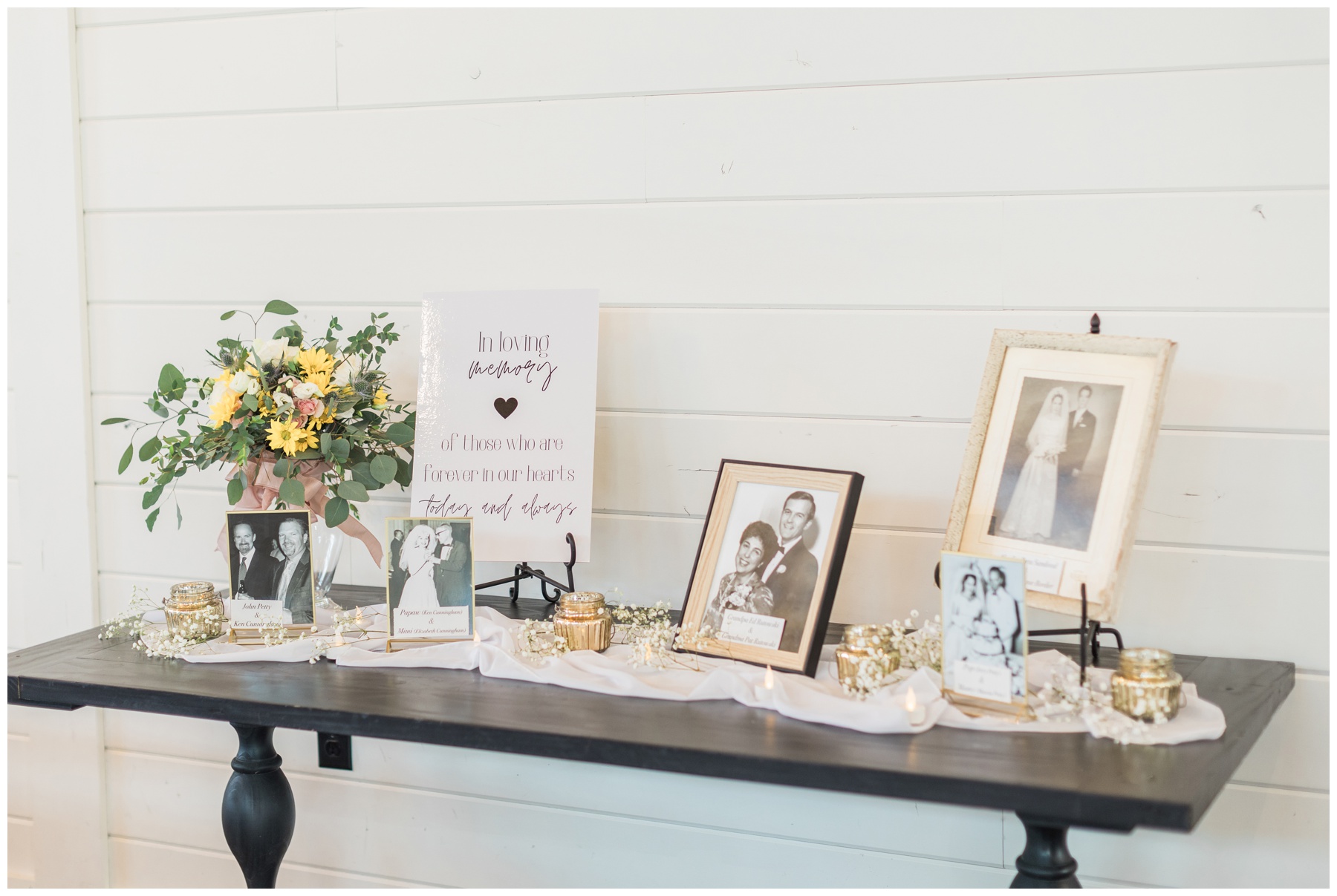 Wedding memory table with framed photos and a vase of flowers